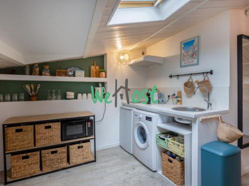 - une buanderie avec un évier et un lave-linge dans l'établissement Atypical studio central, à La Rochelle