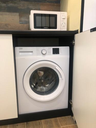 a microwave sitting on top of a washing machine at Cozy apartment near the center in Vinnytsya