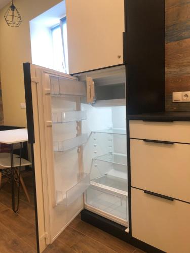 an empty refrigerator with its door open in a kitchen at Cozy apartment near the center in Vinnytsya
