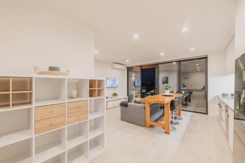 a kitchen and dining room with a wooden table at Tuam St Stay - 1BR with Balcony Bath in Christchurch