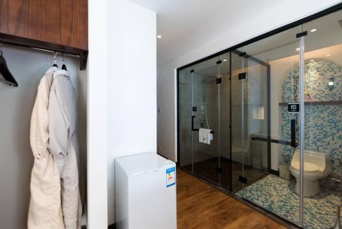 a bathroom with a toilet and a glass shower at Dali Mermaid Seascape Resort Hotel in Dali