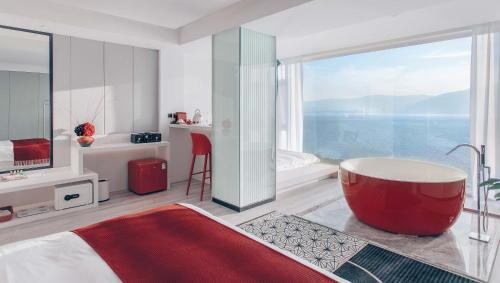 a bedroom with a tub and a view of the ocean at Dali Mermaid Seascape Resort Hotel in Dali