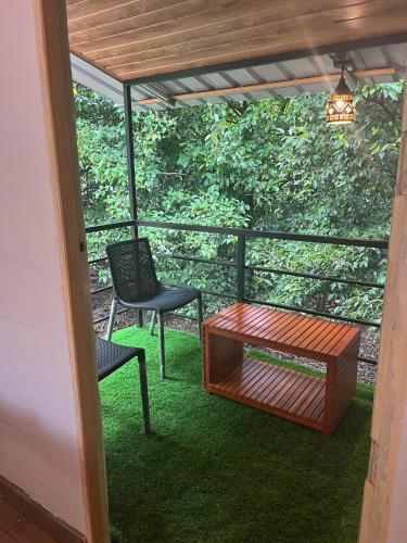 a screened in porch with a table and a chair at Maliyeckal Homestay in Munnar