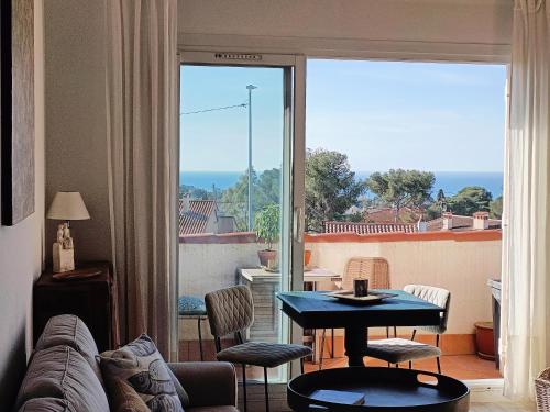 d'un salon avec une table et une vue sur un balcon. dans l'établissement Bleu d' Azur, 4 pers vue mer, gare et coeur de ville 20mn à pied, à Saint-Raphaël