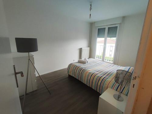 une petite chambre avec un lit et une fenêtre dans l'établissement L'appart de la tour T4, à Pont-de-Chéruy