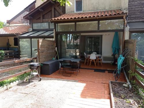 an enclosed patio with a table and chairs at Petit cocon avec terrasse à 150m de l'océan in Soulac-sur-Mer