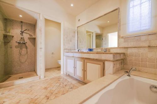 une salle de bain avec une baignoire, une douche et un lavabo dans l'établissement Villa Cramond - avec Piscine pour 8 Pers - Tourrettes-sur-Loup, à Tourrettes-sur-Loup