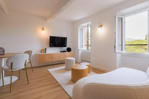 a living room with a couch and a tv at Apt Liberation - Apt standing Centre Tourrettes sur Loup in Tourrettes-sur-Loup