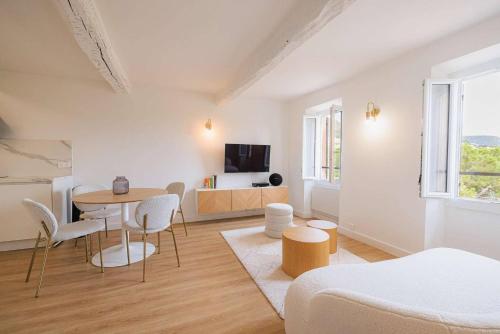 un salon blanc avec une table et des chaises dans l'établissement Apt Liberation - Apt standing Centre Tourrettes sur Loup, à Tourrettes-sur-Loup