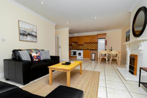 a living room with a black couch and a table at Gort Na Coiribe - Galway Lakeside Apartments in Galway