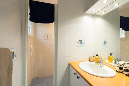 une salle de bain avec un lavabo et une douche dans l'établissement Villa spacieuse au pyla avec piscine et jardin, à La Teste-de-Buch