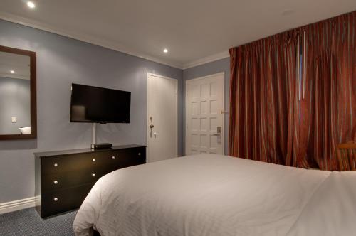 a hotel room with a bed and a television at Vagabond Inn San Pedro in San Pedro