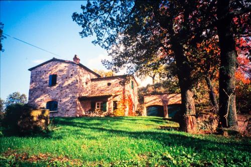 Una antigua casa de piedra en un exuberante campo verde en Le Mille Querce, en Sasso Feltrio