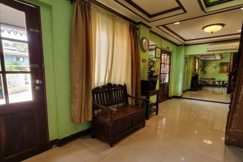 a hallway with green walls and a chair in a room at Mojica Residencia Hotel in Vigan