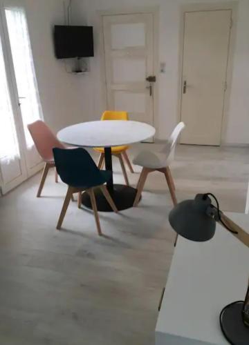 - une table et des chaises blanches dans la chambre dans l'établissement Appartement en RDC, lumineux et spacieux vue sur la montagne, à La Bourboule