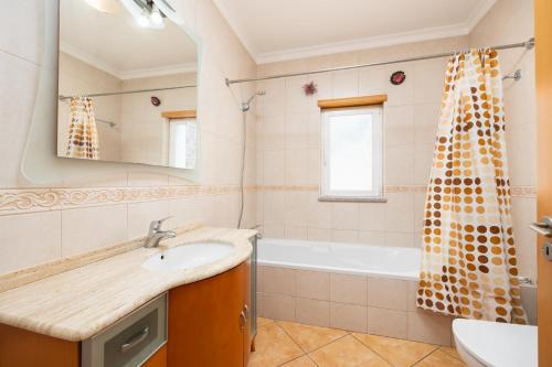 a bathroom with a sink and a tub at Villa Tavagueira in Guia
