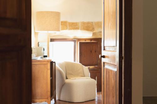 a bedroom with a chair and a desk with a lamp at Reserva Rotana Golf Resort in Manacor