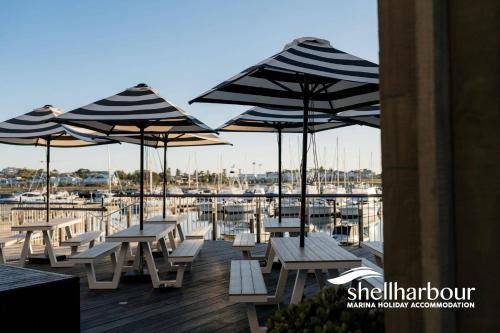 a group of tables and umbrellas on a dock at Hilltop Haven - Shell Cove in Shellharbour