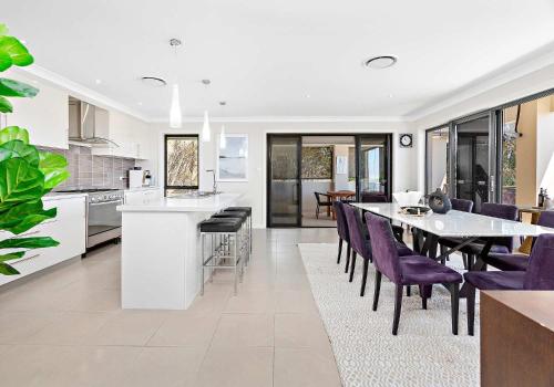 a kitchen and dining room with a table and purple chairs at The Great Escape at Shell Cove in Dunmore