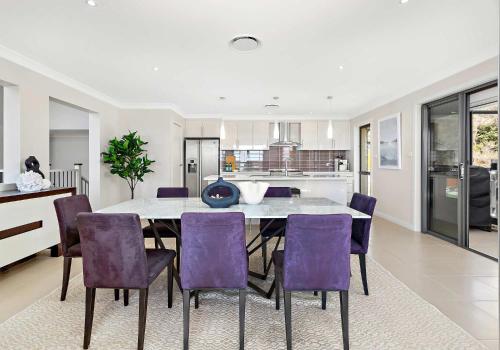 a kitchen and dining room with a table and purple chairs at The Great Escape at Shell Cove in Dunmore