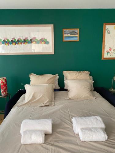 un grand lit avec deux serviettes dessus dans l'établissement Cosy et Arty, à Paris