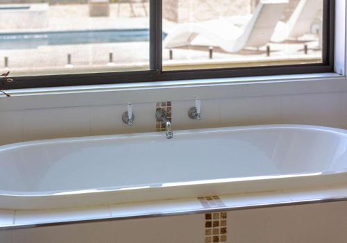 a white bath tub in a bathroom with a window at The Great Escape at Shell Cove in Dunmore