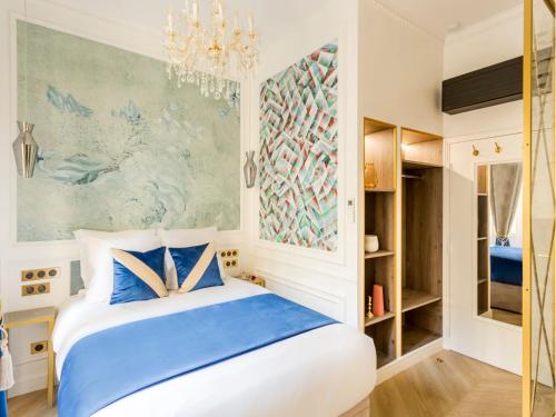 - une chambre avec un lit bleu et blanc et un lustre dans l'établissement Merveil - Luxury Suite - Marais - Republique, à Paris