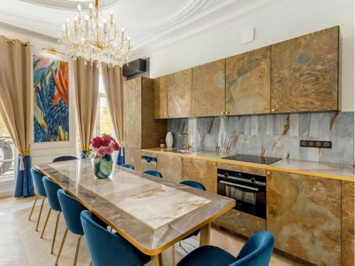 une cuisine avec une grande table en marbre et des chaises bleues dans l'établissement Merveil - Luxury Suite - Marais - Republique, à Paris