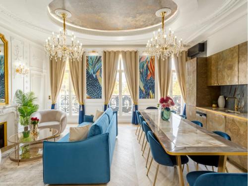 une salle à manger avec des chaises bleues, une table et des lustres dans l'établissement Merveil - Luxury Suite - Marais - Republique, à Paris