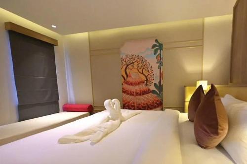 a hotel room with a bed with a towel on it at Hotel De One Dee in Ban Phaet