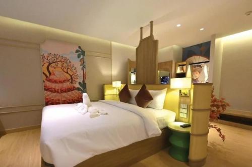 a bedroom with a large white bed in a room at Hotel De One Dee in Ban Phaet