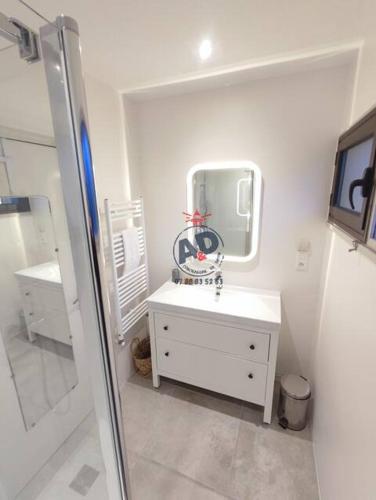 une salle de bain blanche avec un lavabo et un miroir dans l'établissement Villa du Pacific 8pers Lege-cap-ferret, à Lège-Cap-Ferret