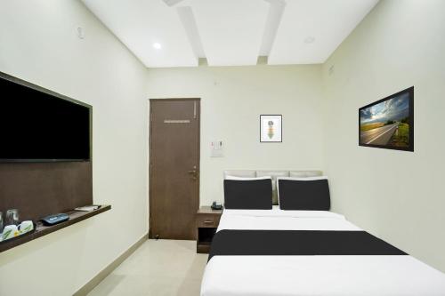 a hotel room with two beds and a flat screen tv at Super Hotel O CITY HEIGHTS in Dhanbād