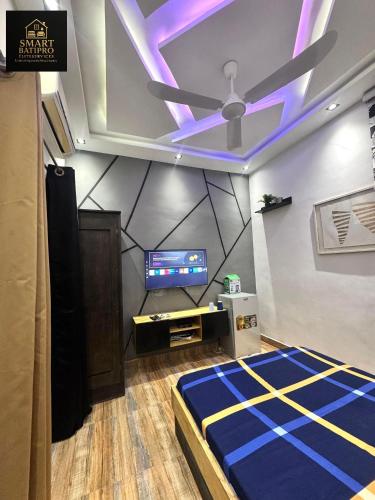 a room with a ceiling fan and a tv at SMART BÂTIPRO Studio 2 in Cotonou