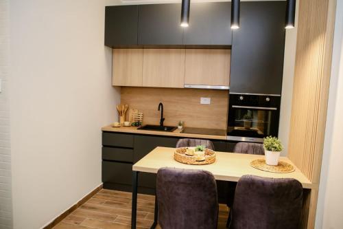 a kitchen with a table and some purple chairs at POOL RESORT- Vila Lena- Apartman 2 in Vrdnik