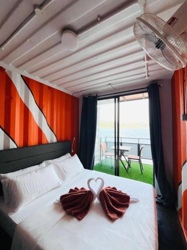 a bedroom with a bed with two swans in the middle at Perhentian Nemo Chalet in Perhentian Island