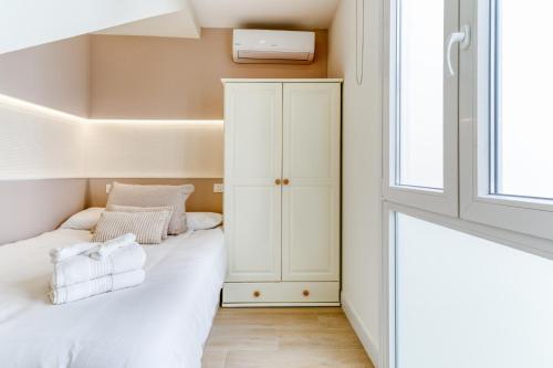 a small bedroom with a bed and a window at Cala Luna-few steps from the beach in La Cala de Mijas