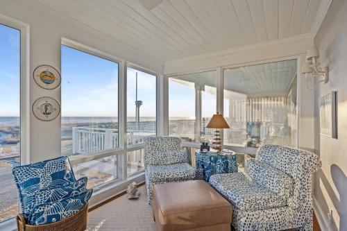 een woonkamer met 2 stoelen, een bank en ramen bij Taylor Cottage home in Atlantic Beach