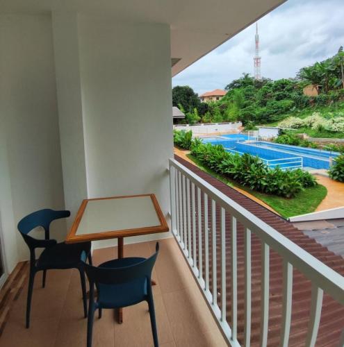 a balcony with a table and chairs and a swimming pool at Casa Bella Bacolod in Bacolod