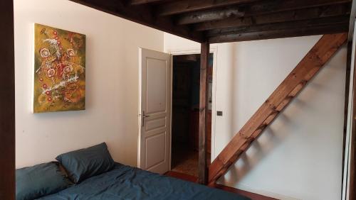 une chambre avec un lit et un tableau au mur dans l'établissement Maison de ville, à La Celle-sous-Gouzon