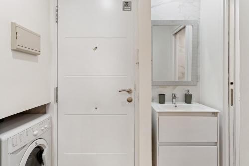 a white laundry room with a sink and a washing machine at Cala Arena-few steps from the beach in La Cala de Mijas
