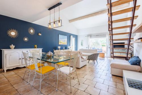 un salon avec une table en verre et des chaises dans l'établissement Lavande - maison climatisée avec grand jardin, à Cabrières-dʼAvignon