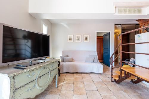 un salon avec une grande télévision à écran plat dans l'établissement Lavande - maison climatisée avec grand jardin, à Cabrières-dʼAvignon