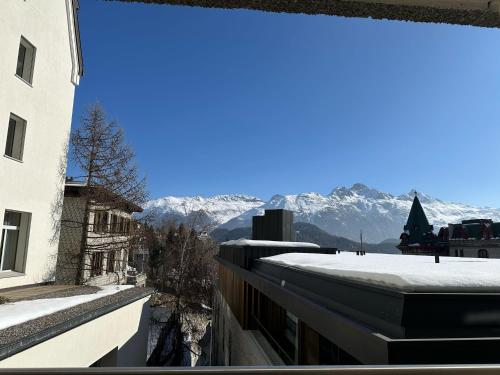 a view of the mountains from the balcony of a building at Appartamento centrale in St. Moritz
