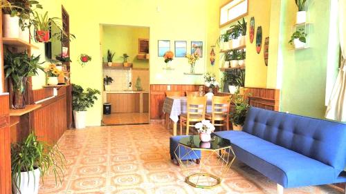 a living room with a blue couch and a table at Blue Sea House Quảng Bình - Căn hộ 2 phòng ngủ, phòng khách và phòng bếp in Dong Hoi