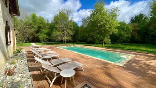 a group of lounge chairs next to a swimming pool at Gîte le Moulin Samsara in Homps