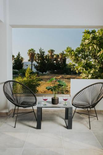 two chairs and a table with two glasses of wine at Relax Villa in Marmari