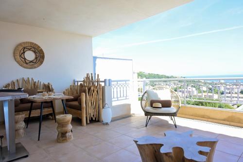 un salon avec une table et des chaises et un balcon dans l'établissement Appartement de standing Île-Rousse - Grande terrasse vue mer exceptionnelle, à LʼÎle-Rousse