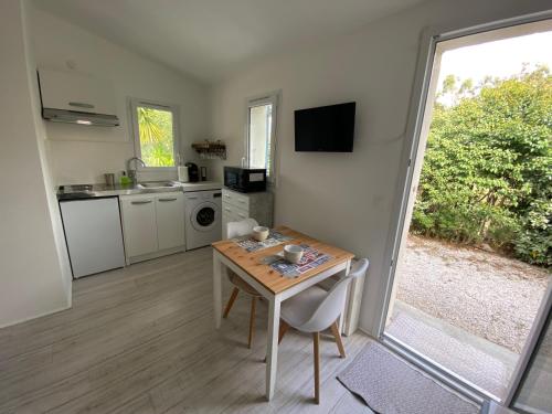 une cuisine et une salle à manger avec une table et une fenêtre dans l'établissement Casina Calenzana, à Calenzana