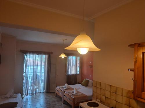a room with a bed and a table and a lamp at Elli Marina Studios & Apts Benitses Mare in Benitses